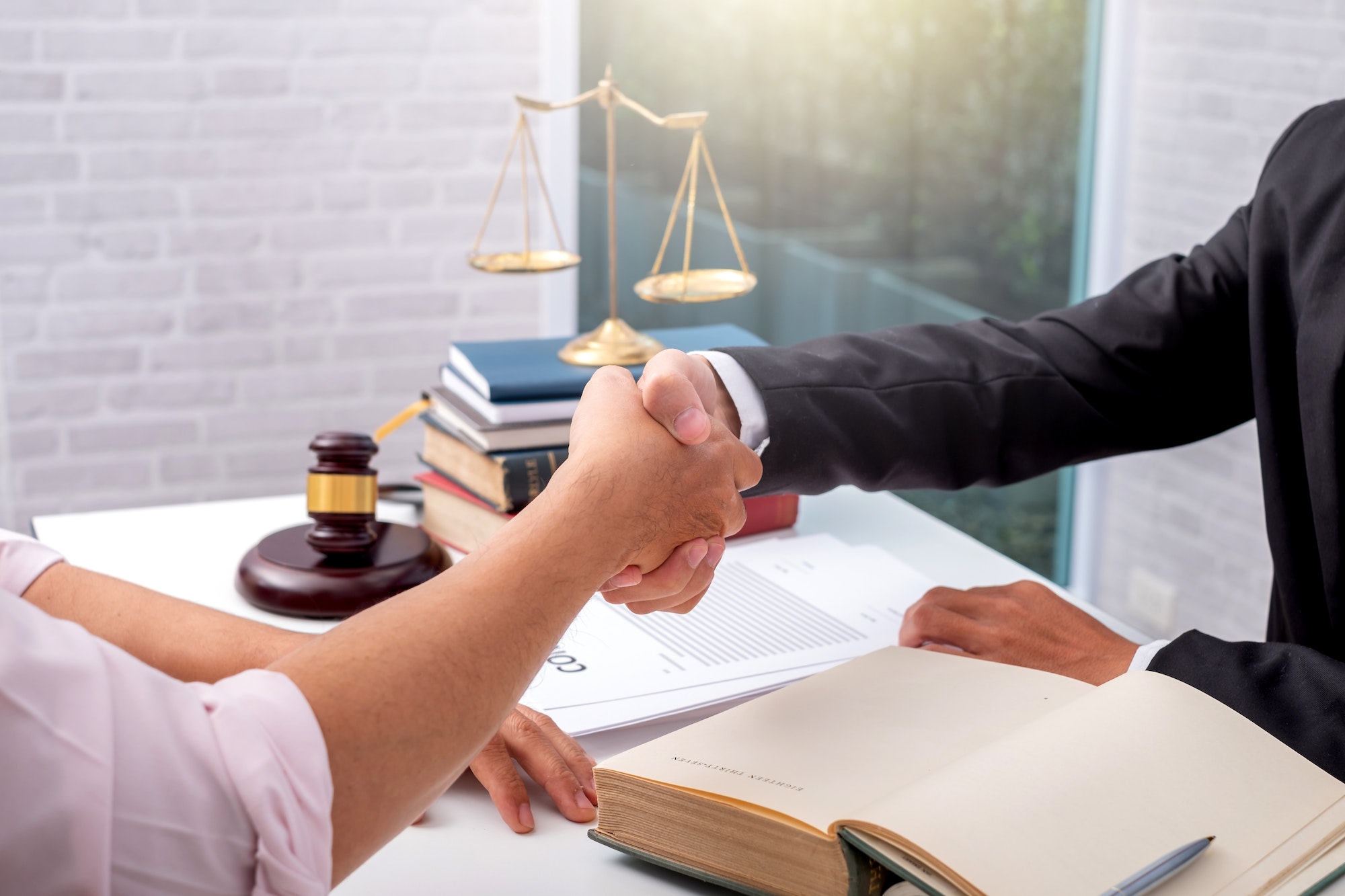 Businessman shaking hands to seal a deal with his partner lawyers or attorney